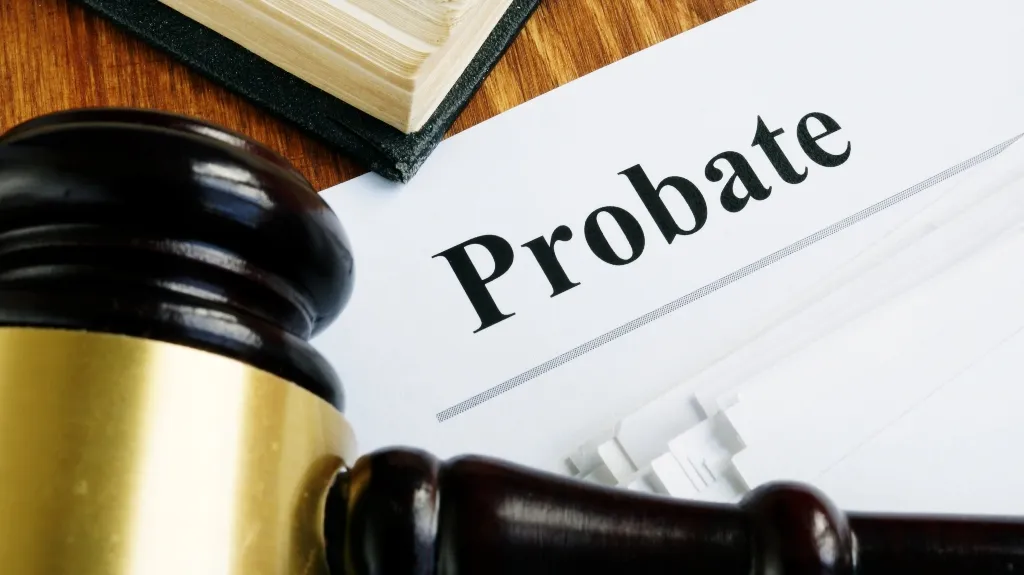 Close-up of a wooden gavel, legal book, and document titled "Probate" on a wooden surface.