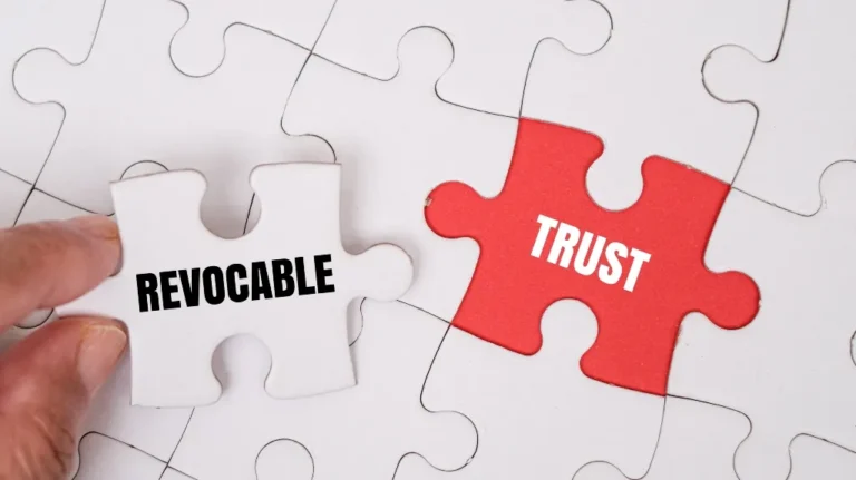 Hand holding a white puzzle piece labeled "REVOCABLE" near a red puzzle piece labeled "TRUST" on a white puzzle background.