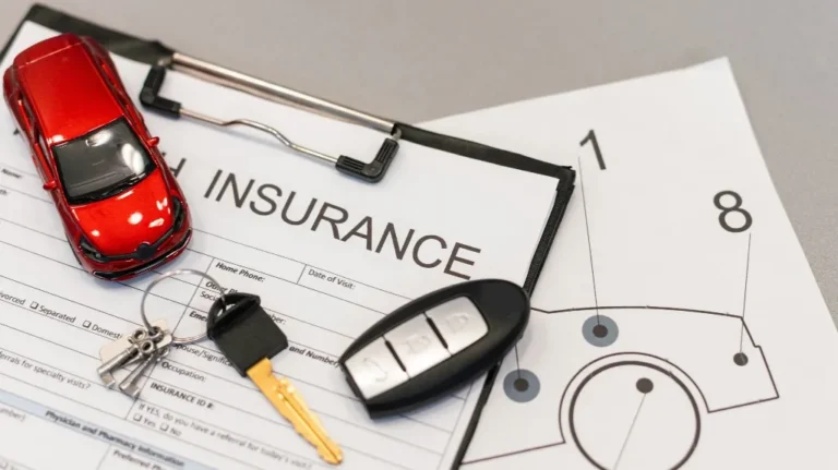 Car insurance form on clipboard with red toy car and car keys placed on top.